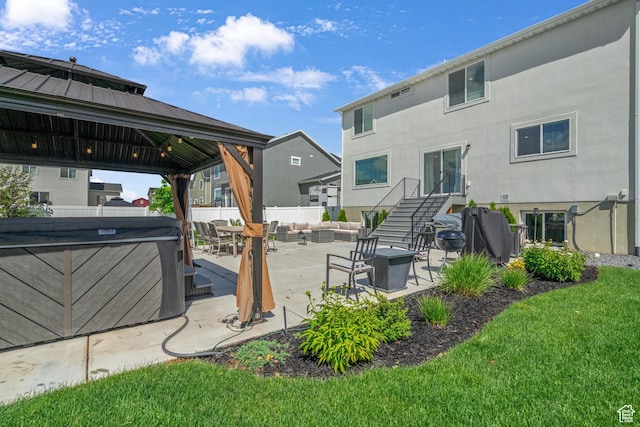 4185 W 800 S, Syracuse, UT 84075 - rear view of property featuring an outdoor living space with a fire pit, a gazebo, stucco siding, a patio area, and a hot tub