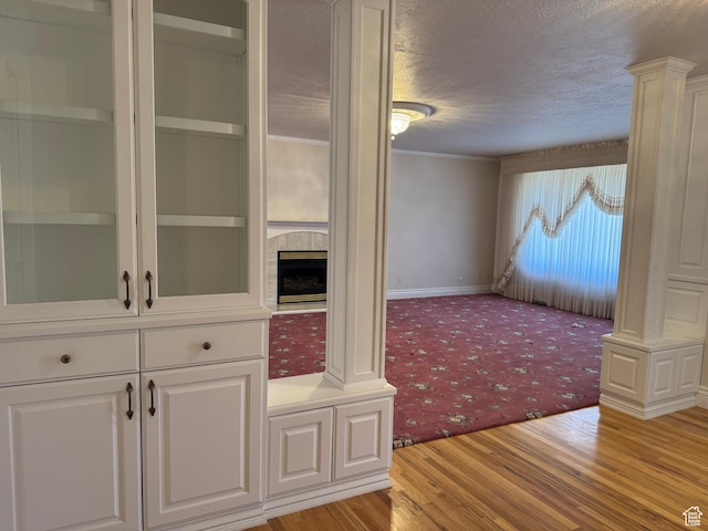 2650 S 2000 W, Syracuse, UT 84075 - unfurnished dining area featuring a textured ceiling, light wood finished floors, light carpet, a fireplace, and baseboards
