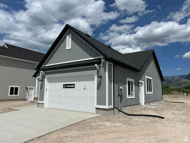 570 N 600 W, Smithfield, UT 84335 - view of front of house featuring concrete driveway, board and batten siding, a mountain view, and a garage