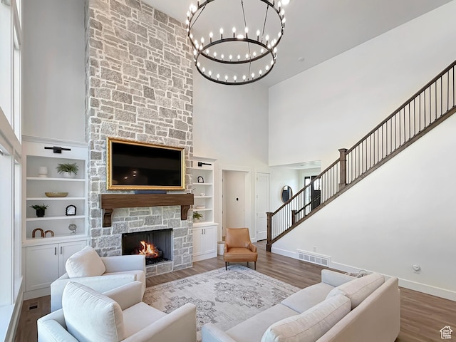 2558 N 1150 E, North Ogden, UT 84414 - living area featuring a towering ceiling, baseboards, a chandelier, a stone fireplace, and wood finished floors