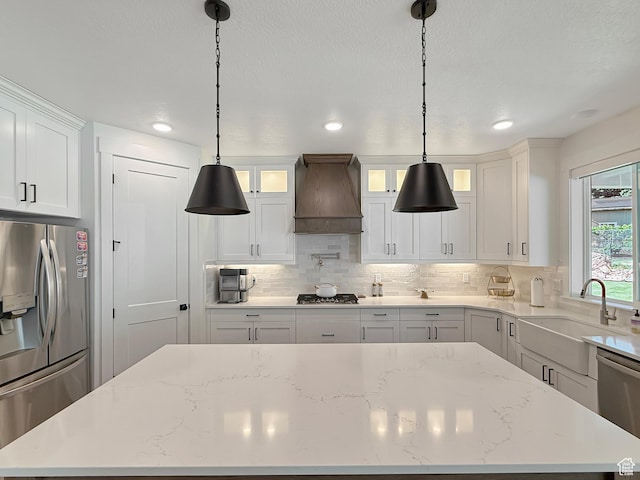 2558 N 1150 E, North Ogden, UT 84414 - kitchen with stainless steel appliances, custom range hood, a center island, white cabinets, and a sink
