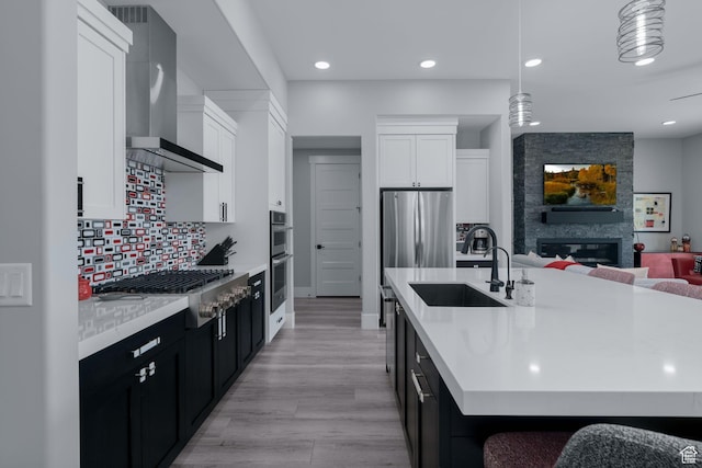 11579 N Groves Edge Dr, Hideout, UT 84036 - kitchen with wall chimney range hood, stainless steel appliances, dark cabinets, a sink, and light countertops