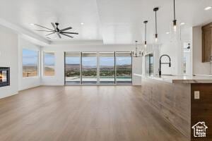 579 S 1800 W, Hurricane, UT 84737 - unfurnished living room with wood finished floors, healthy amount of natural light, a ceiling fan, and a glass covered fireplace