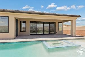 579 S 1800 W, Hurricane, UT 84737 - rear view of house with a storage structure, an outdoor structure, stucco siding, and a pool with connected hot tub
