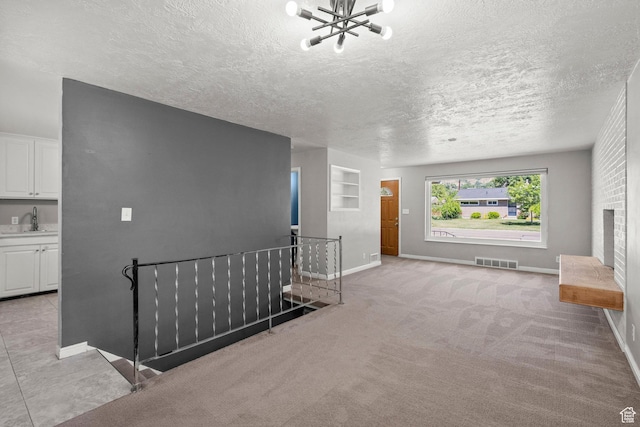 3025 N 250 E, Provo, UT 84604 - unfurnished living room featuring a sink, a chandelier, a textured ceiling, baseboards, and light colored carpet
