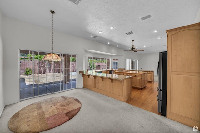 3350 S Fairway Rd, St George, UT 84790 - kitchen with freestanding refrigerator, recessed lighting, a ceiling fan, a kitchen breakfast bar, and a textured ceiling