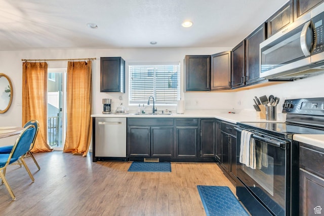 2987 S Willow Creek Dr, Saratoga Springs, UT 84045 - kitchen featuring stainless steel appliances, a sink, light countertops, light wood finished floors, and recessed lighting