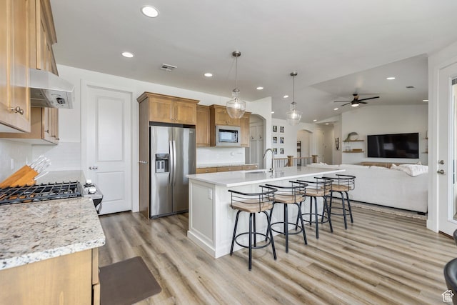1432 Boys Pond Cir, Santa Clara, UT 84765 - kitchen featuring stainless steel appliances, arched walkways, under cabinet range hood, a breakfast bar, and recessed lighting