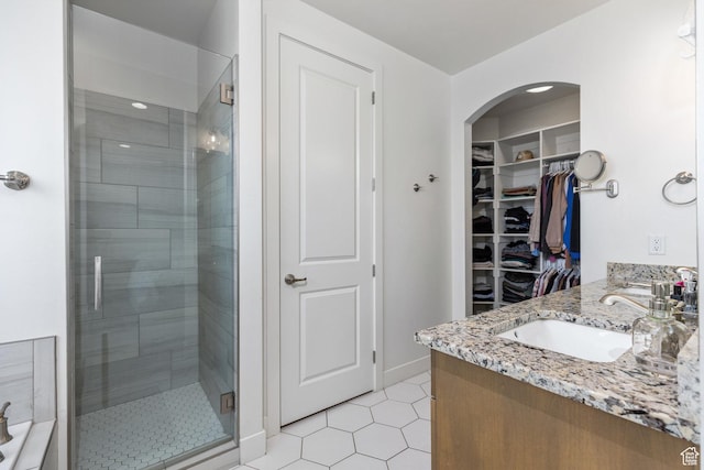 1432 Boys Pond Cir, Santa Clara, UT 84765 - bathroom featuring a shower stall, a walk in closet, double vanity, baseboards, and tile patterned flooring