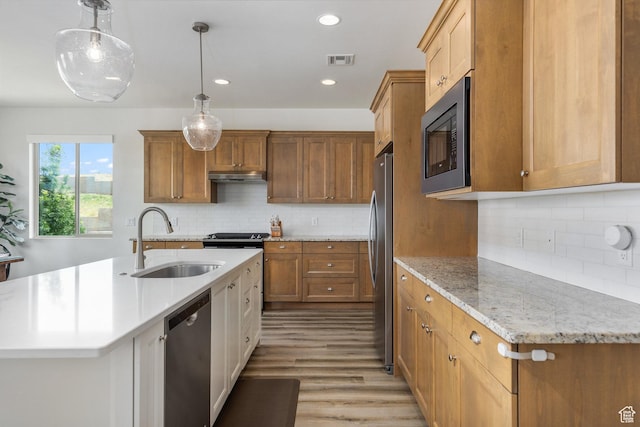 1432 Boys Pond Cir, Santa Clara, UT 84765 - kitchen featuring stainless steel appliances, tasteful backsplash, an island with sink, light wood-style floors, and brown cabinets