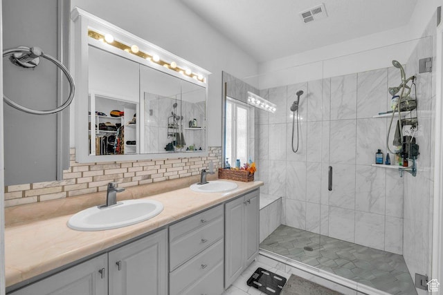 1165 W Indian Hills Dr Unit 236, St George, UT 84770 - bathroom with a shower stall, double vanity, backsplash, a walk in closet, and tile patterned flooring