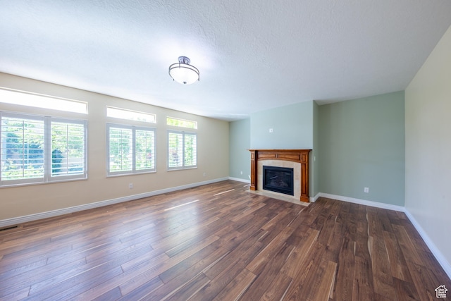 407 E Clay Ln, Lehi, UT 84043 - unfurnished living room featuring dark wood-type flooring, a tile fireplace, baseboards, and a textured ceiling