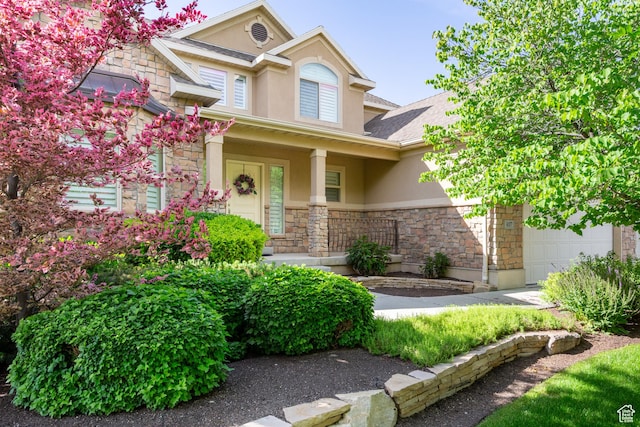 407 E Clay Ln, Lehi, UT 84043 - view of front of home featuring stucco siding, stone siding, a garage, and covered porch