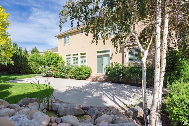 407 E Clay Ln, Lehi, UT 84043 - rear view of house with stucco siding, a patio area, and a lawn