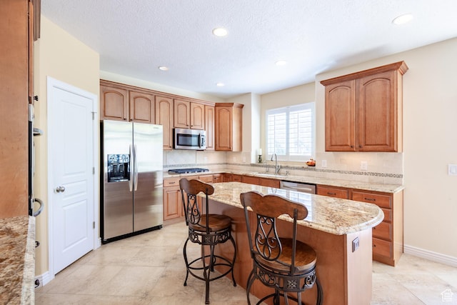 407 E Clay Ln, Lehi, UT 84043 - kitchen with appliances with stainless steel finishes, a sink, a breakfast bar area, light stone countertops, and a center island