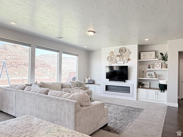 5893 S Kastra Ln, St George, UT 84790 - living area with a large fireplace, dark wood-type flooring, recessed lighting, and a textured ceiling