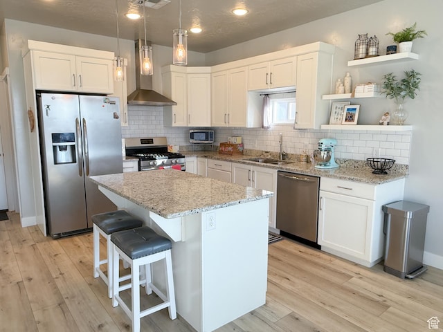 5893 S Kastra Ln, St George, UT 84790 - kitchen with appliances with stainless steel finishes, open shelves, wall chimney exhaust hood, light wood-style flooring, and recessed lighting