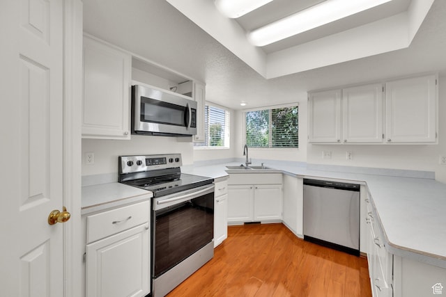 1261 E Hillsden Rd N, Layton, UT 84040 - kitchen with stainless steel appliances, a sink, light countertops, light wood-type flooring, and white cabinetry
