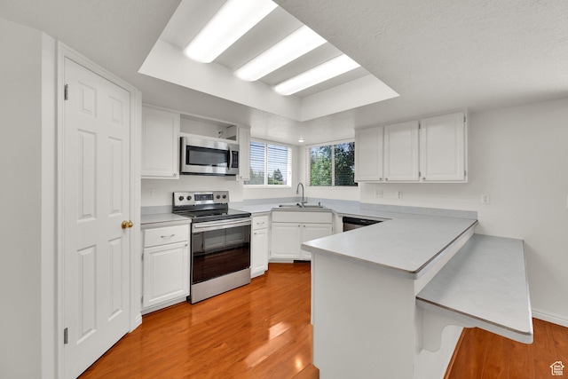 1261 E Hillsden Rd N, Layton, UT 84040 - kitchen with appliances with stainless steel finishes, a peninsula, a sink, and light wood-style flooring