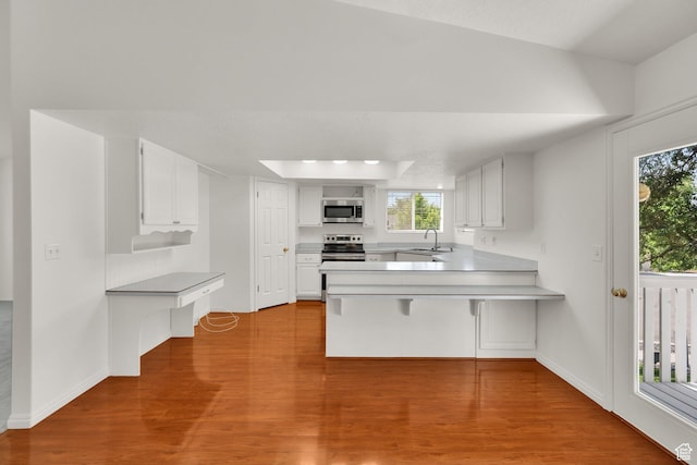 1261 E Hillsden Rd N, Layton, UT 84040 - kitchen with appliances with stainless steel finishes, a sink, a peninsula, wood finished floors, and white cabinetry