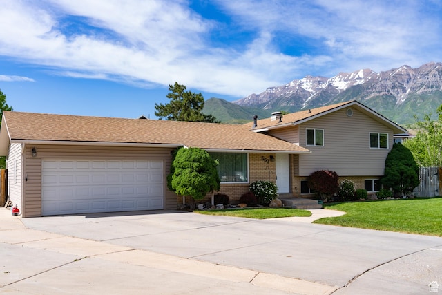 557 N 1160 E, Orem, UT 84097 - split level home with a mountain view, concrete driveway, brick siding, a garage, and roof with shingles