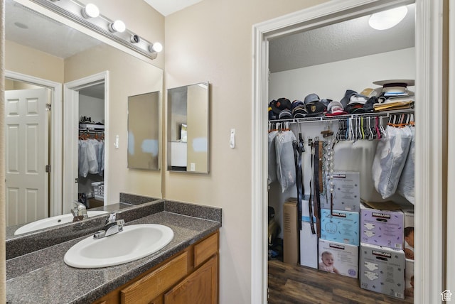 56 E Resaca Dr Unit A-12, Sandy, UT 84070 - bathroom featuring vanity, a spacious closet, and wood finished floors
