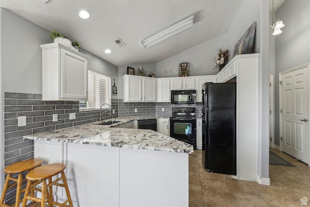 56 E Resaca Dr Unit A-12, Sandy, UT 84070 - kitchen with black appliances, a sink, a peninsula, white cabinets, and light stone counters