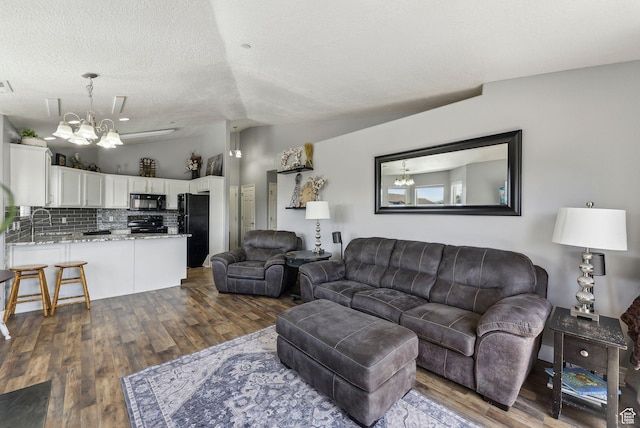 56 E Resaca Dr Unit A-12, Sandy, UT 84070 - living area with lofted ceiling, a chandelier, dark wood finished floors, and a textured ceiling