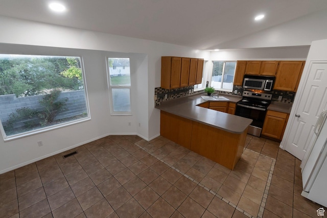 3388 W Briar Dr S, West Jordan, UT 84084 - kitchen with appliances with stainless steel finishes, a peninsula, tasteful backsplash, vaulted ceiling, and recessed lighting