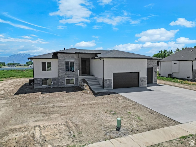4594 S 6300 W, Hooper, UT 84315 - view of front of property with stone siding, a garage, driveway, and a mountain view