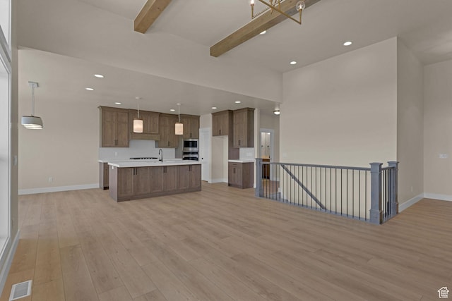 4594 S 6300 W, Hooper, UT 84315 - kitchen featuring open floor plan, beamed ceiling, light wood finished floors, light countertops, and a center island with sink