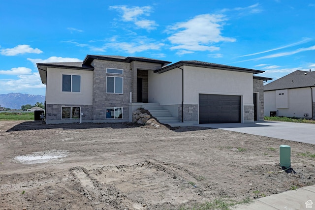 4594 S 6300 W, Hooper, UT 84315 - prairie-style house with stone siding, concrete driveway, an attached garage, and a mountain view