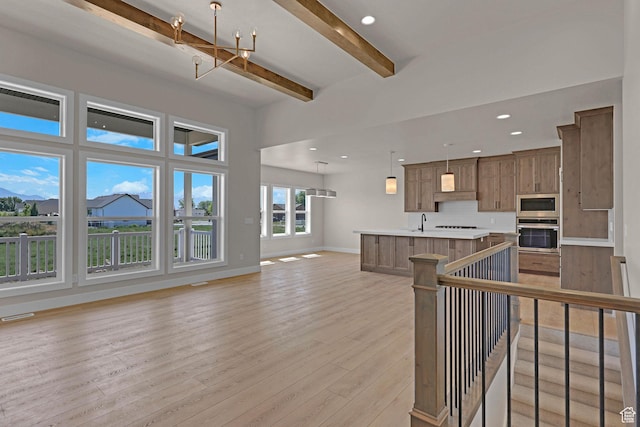 4594 S 6300 W, Hooper, UT 84315 - kitchen featuring stainless steel appliances, open floor plan, light countertops, beamed ceiling, and light wood-style flooring