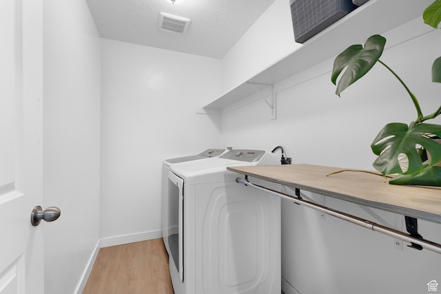 1815 E Thunder Gulch Rd, Eagle Mountain, UT 84005 - laundry area featuring washing machine and dryer, light wood finished floors, and baseboards