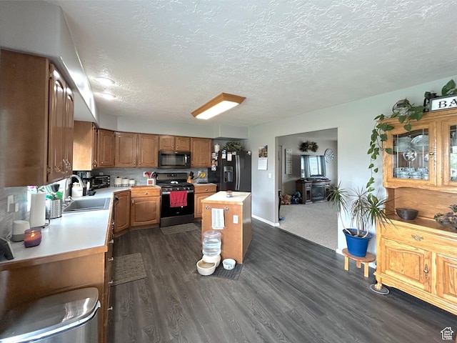434 S 2nd E, Soda Springs, ID 83276 - kitchen featuring black appliances, a sink, light countertops, a kitchen island, and a textured ceiling