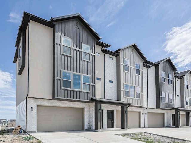 610 W Caroles Way Unit 11, Tooele, UT 84074 - townhome / multi-family property with an attached garage, board and batten siding, concrete driveway, and brick siding