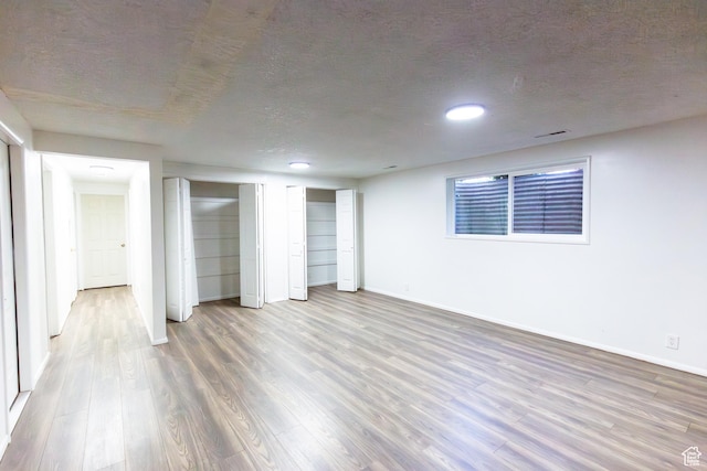875 W 1130 N, Orem, UT 84057 - unfurnished bedroom featuring wood finished floors, baseboards, two closets, and a textured ceiling