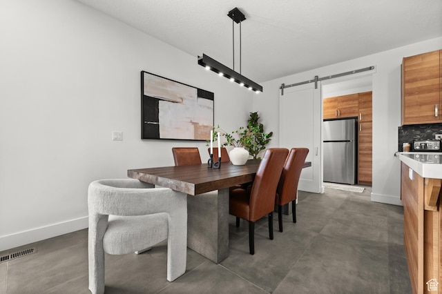 507 W Windmill Gate Cv, Draper, UT 84020 - dining space featuring a barn door, finished concrete flooring, and baseboards