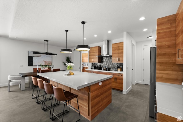 507 W Windmill Gate Cv, Draper, UT 84020 - kitchen with wall chimney range hood, brown cabinetry, baseboards, tasteful backsplash, and recessed lighting