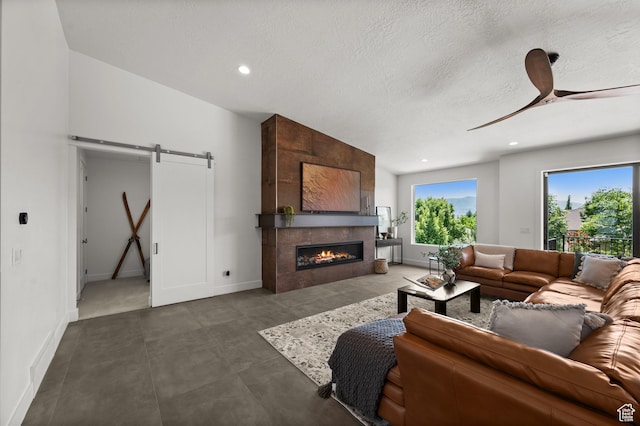 507 W Windmill Gate Cv, Draper, UT 84020 - living room with a barn door, a ceiling fan, baseboards, recessed lighting, and a tile fireplace
