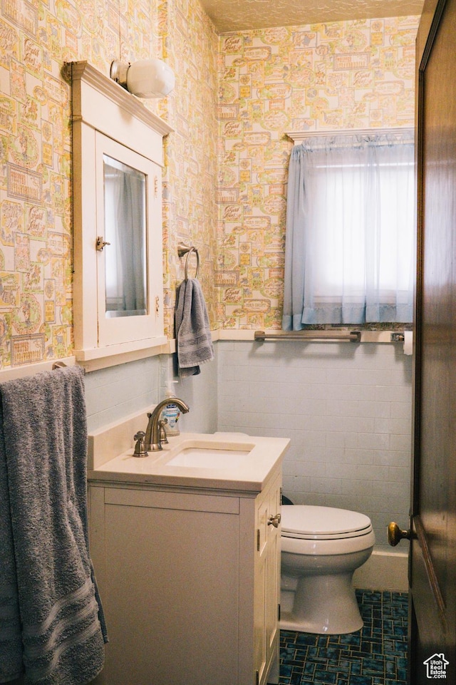 201 Bannock St, Malad City, ID 83252 - bathroom with wallpapered walls, wainscoting, toilet, and vanity