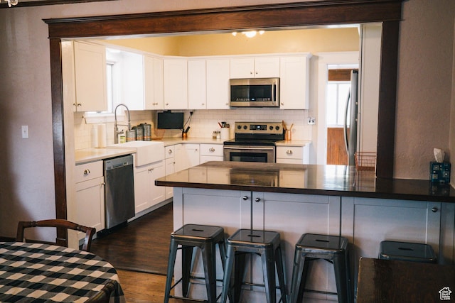 201 Bannock St, Malad City, ID 83252 - kitchen with appliances with stainless steel finishes, a sink, tasteful backsplash, and white cabinetry