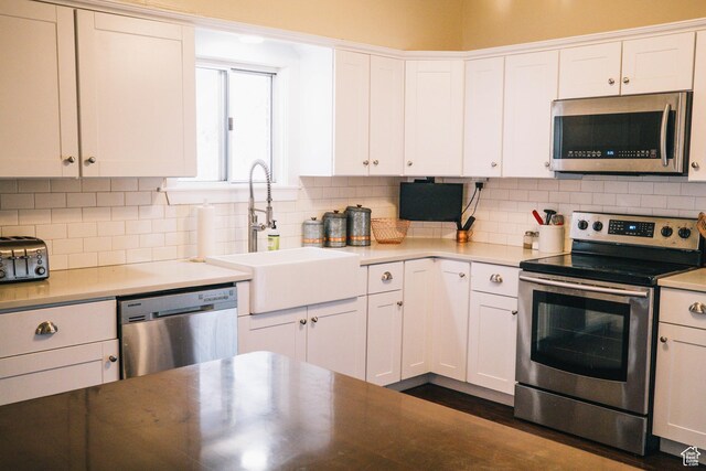 201 Bannock St, Malad City, ID 83252 - kitchen with appliances with stainless steel finishes, a sink, white cabinets, and tasteful backsplash