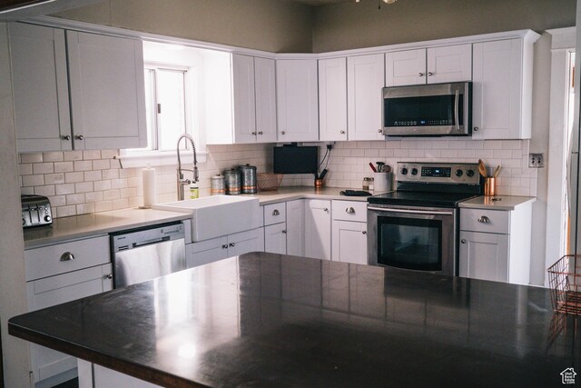 201 Bannock St, Malad City, ID 83252 - kitchen with stainless steel appliances, a sink, decorative backsplash, and white cabinetry