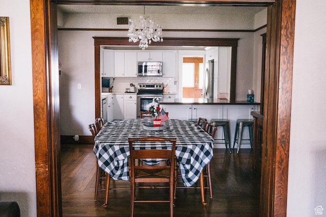 201 Bannock St, Malad City, ID 83252 - dining room featuring a chandelier, dark wood finished floors, and baseboards