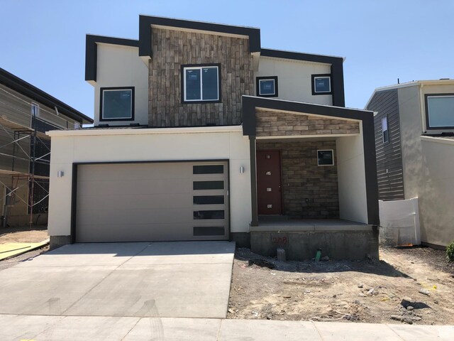 264 E Cedar Ln Unit 208, Midvale, UT 84070 - modern home with an attached garage, concrete driveway, stucco siding, stone siding, and covered porch