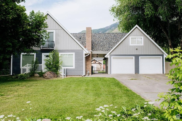 1271 S Main St S, Mapleton, UT 84664 - view of front of property with a front lawn, a balcony, a chimney, driveway, and board and batten siding