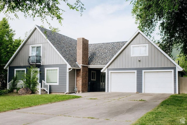 1271 S Main St S, Mapleton, UT 84664 - view of front facade featuring a balcony, a chimney, driveway, a shingled roof, and board and batten siding