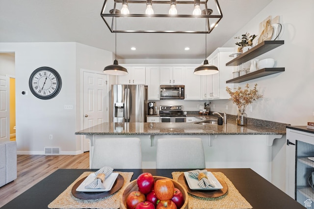 819 E 12085 S, Draper, UT 84020 - kitchen featuring stainless steel appliances, a sink, open shelves, light wood-style flooring, and a peninsula