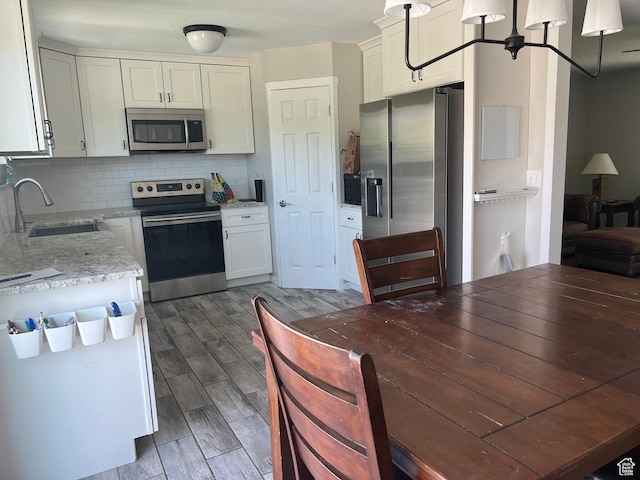8842 E 500 S, Huntsville, UT 84317 - kitchen with stainless steel appliances, a sink, tasteful backsplash, wood finished floors, and light stone countertops